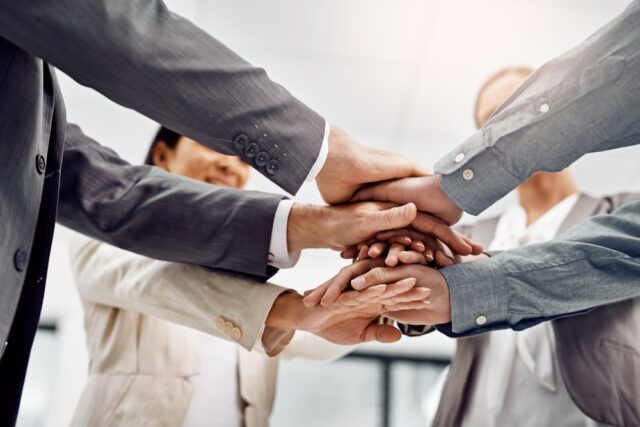 Hands, stack and group of business people in office for team building, motivation and solidarity. Attorney, lawyer or advocate in low angle for staff with support in corporate law firm for goals